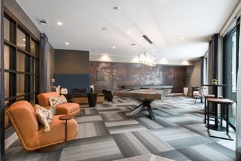 A modern living room with a pool table and a couch.